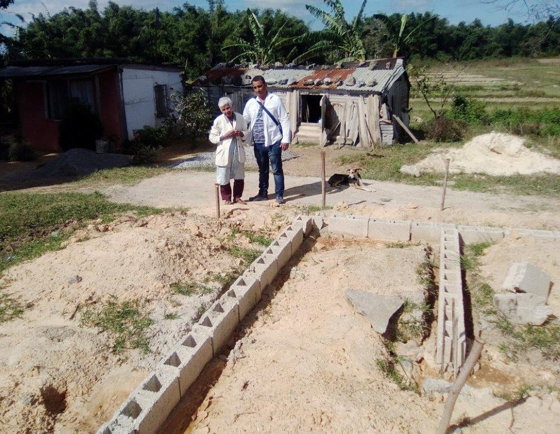 Esta anciana espera por su nueva casa antes de que lleguen las lluvias. Al fondo donde reside actualmente